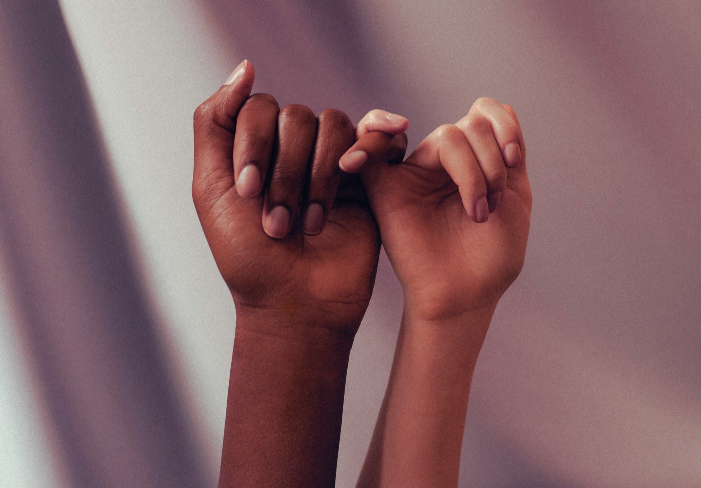 Two hands linked in a pinky promise